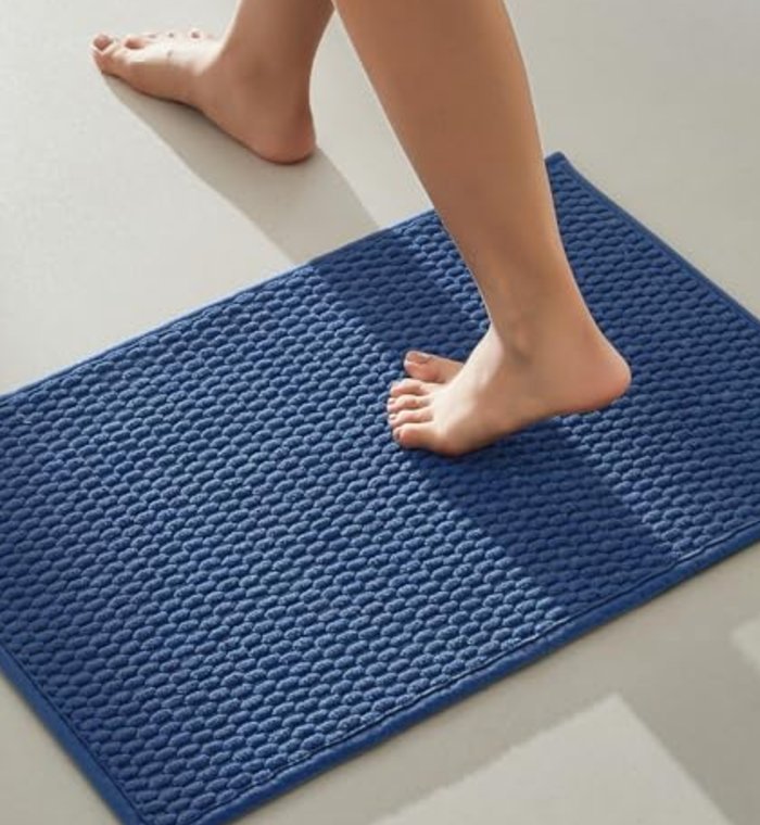 A navy TYUU bath mat, fresh from the wash
